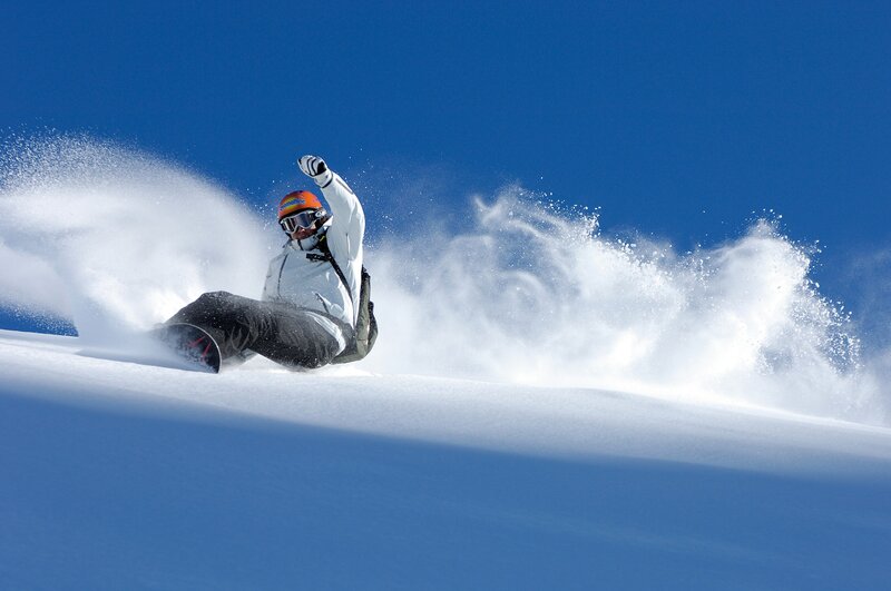 Snowboarder carving on a sunny day