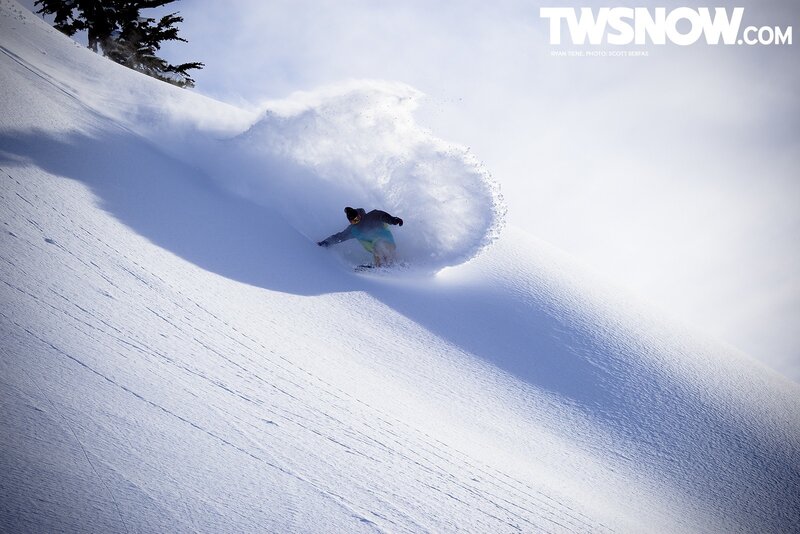 Snowboarder carving through powder
