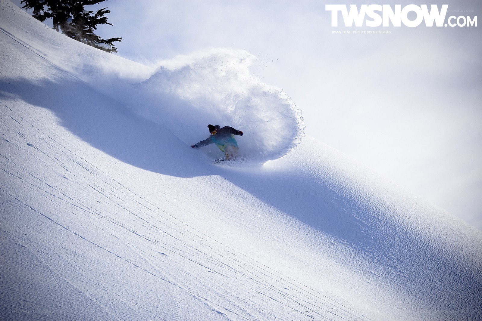 Snowboarder carving through powder