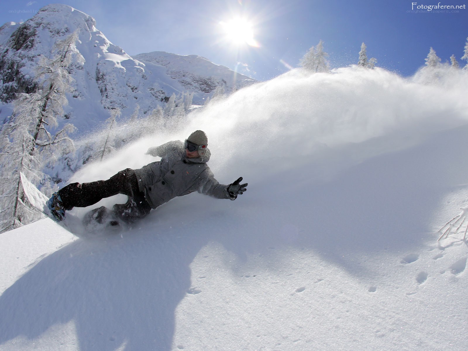Snowboarder carving through powder