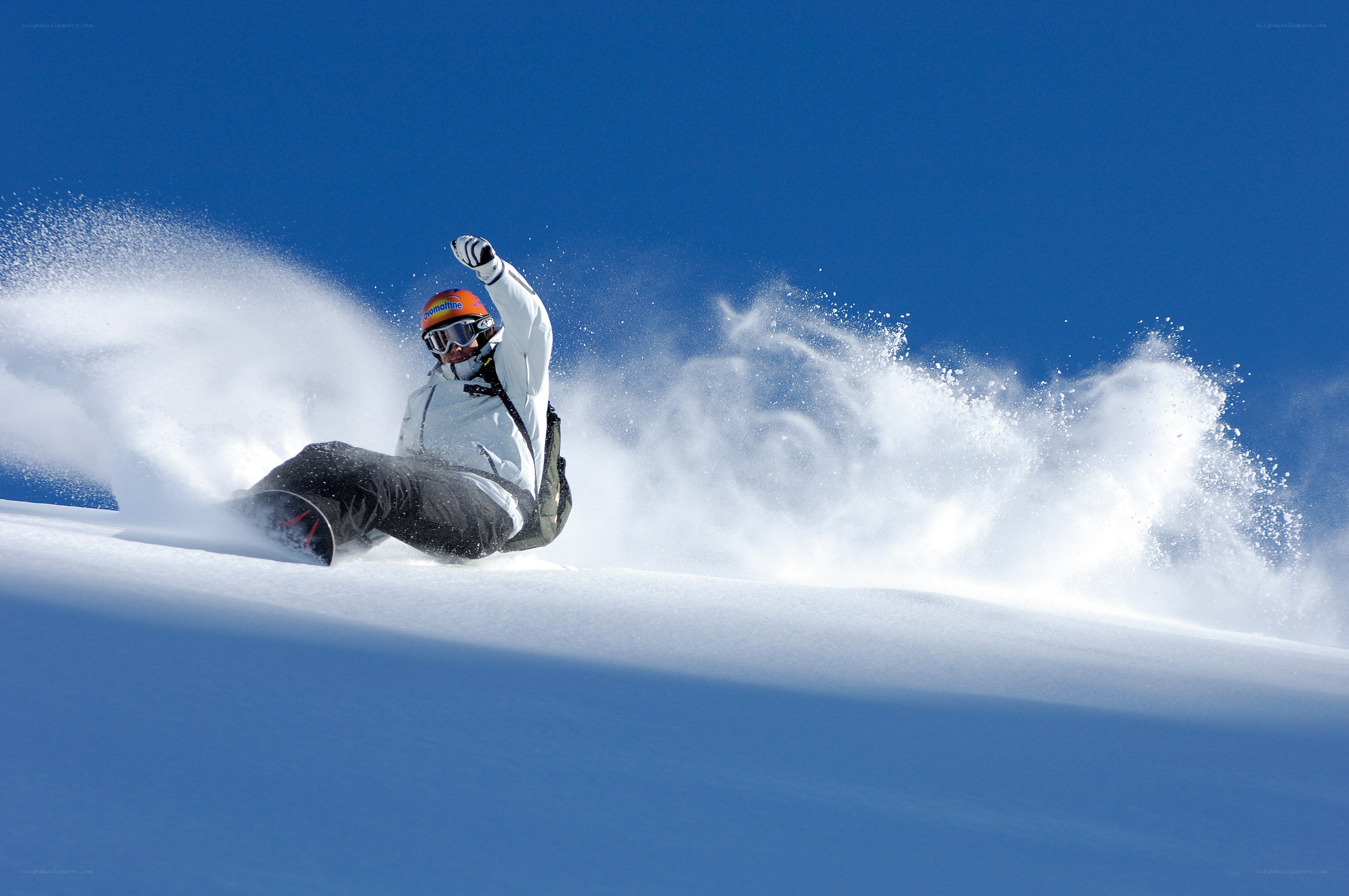 Snowboarder carving through powder