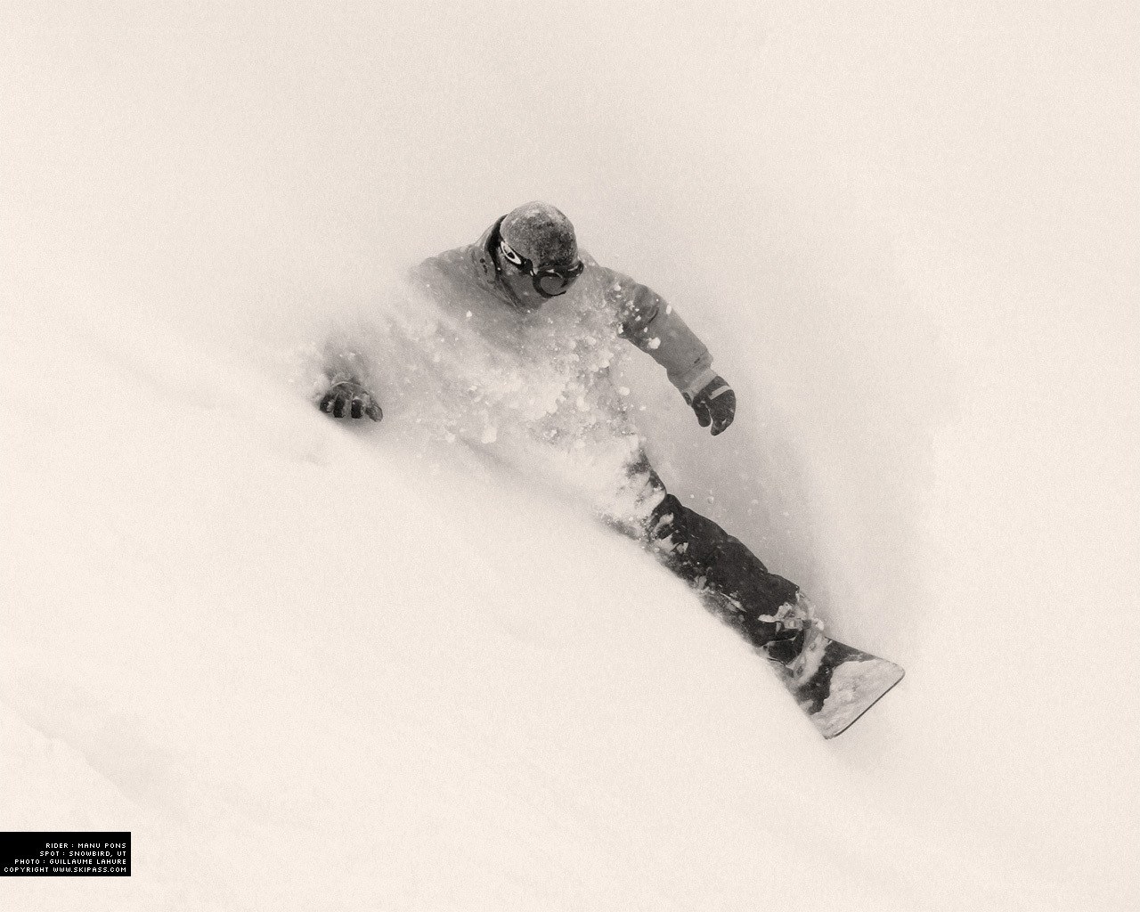 Snowboarder carving through powder