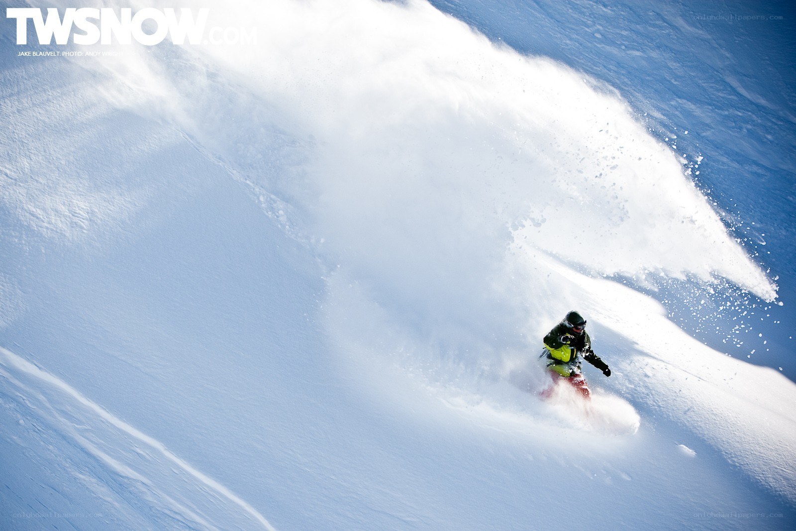 Snowboarder carving through powder