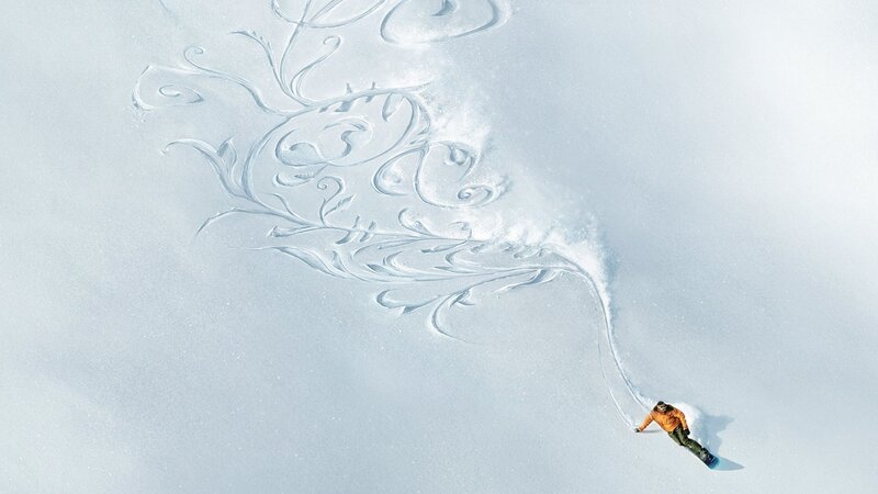 Snowboarder creating art in snow