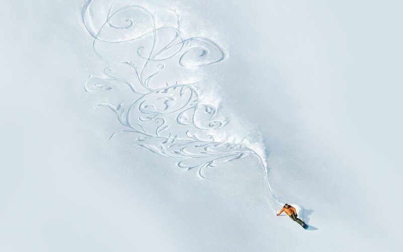Snowboarder creating art in snow