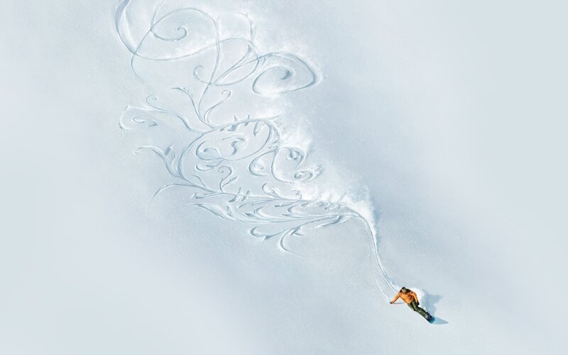 Snowboarder creating art in snow