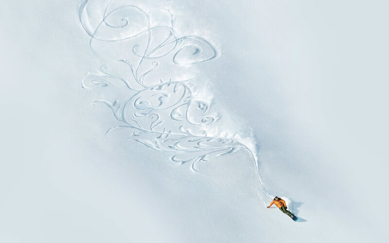 Snowboarder drawing art in snow