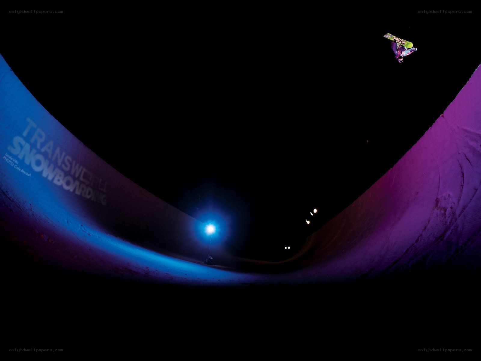 Snowboarder in halfpipe at night