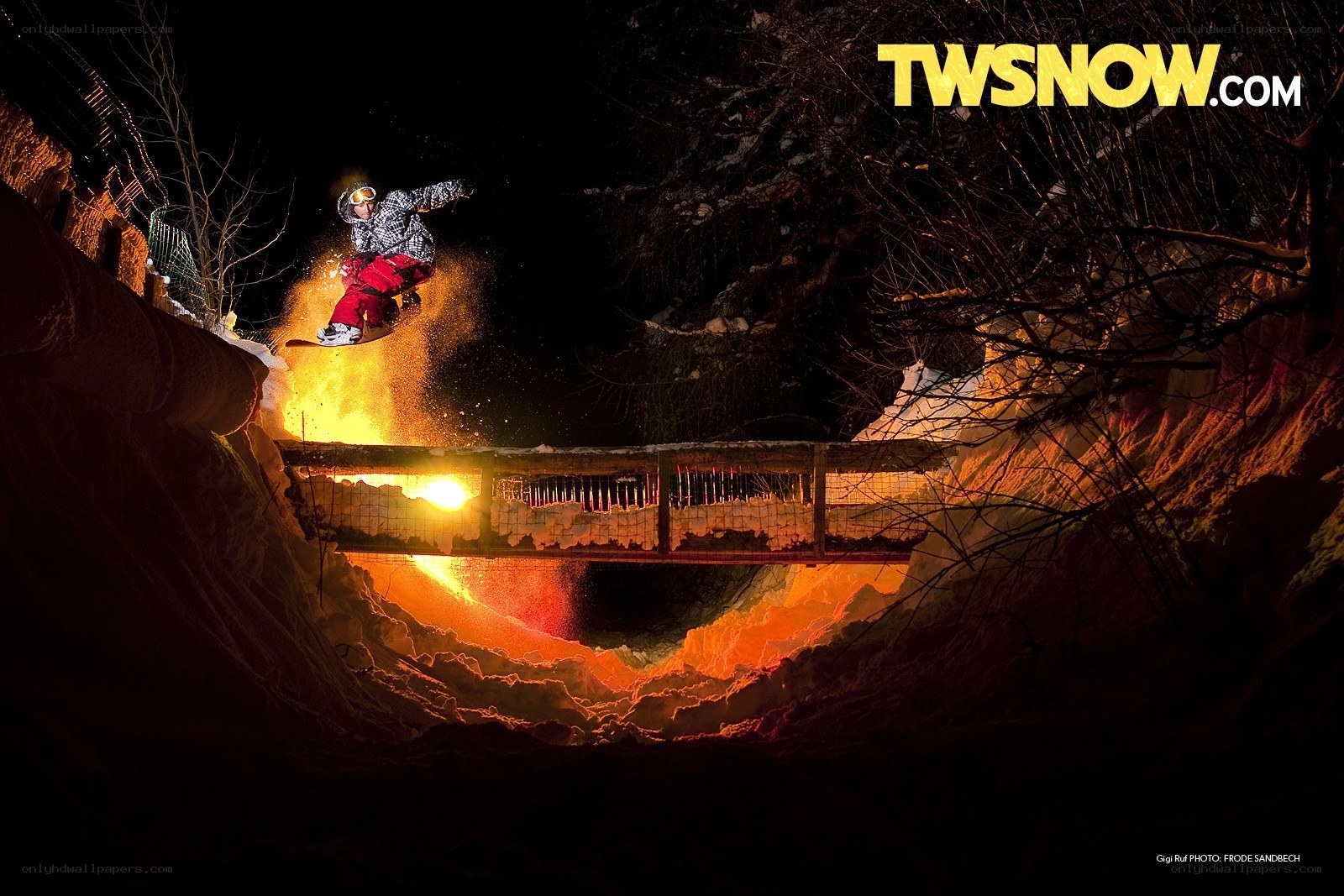 snowboarder jumping at night