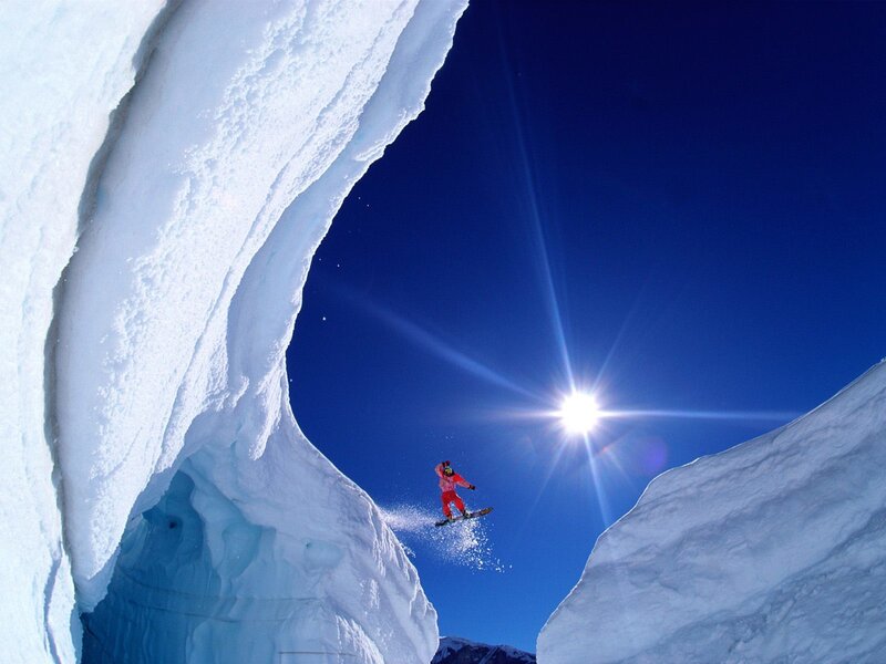 Snowboarder jumping in snow tunnel