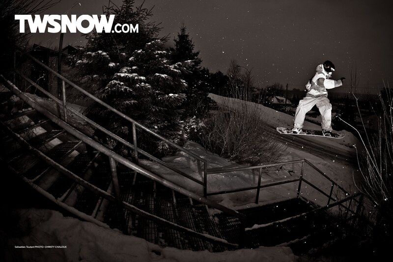 Snowboarder jumping stairs at night