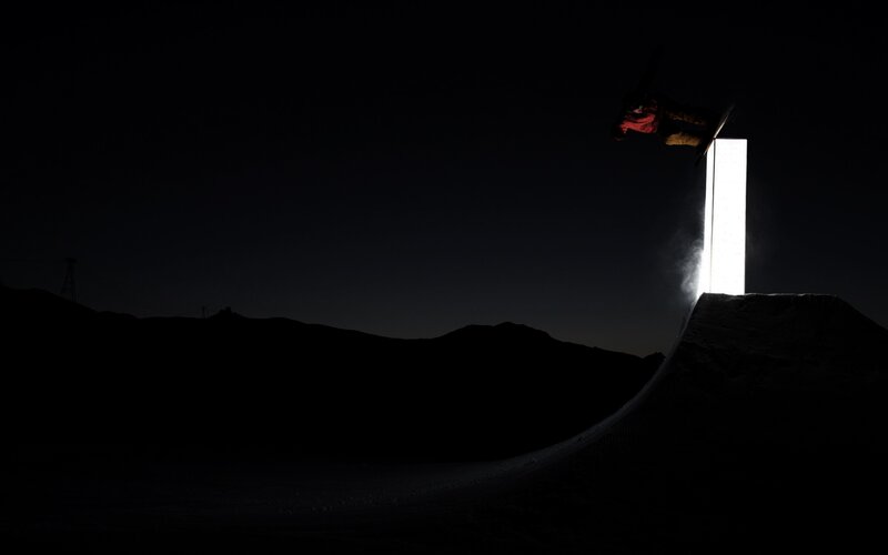 Snowboarder mid-air at night