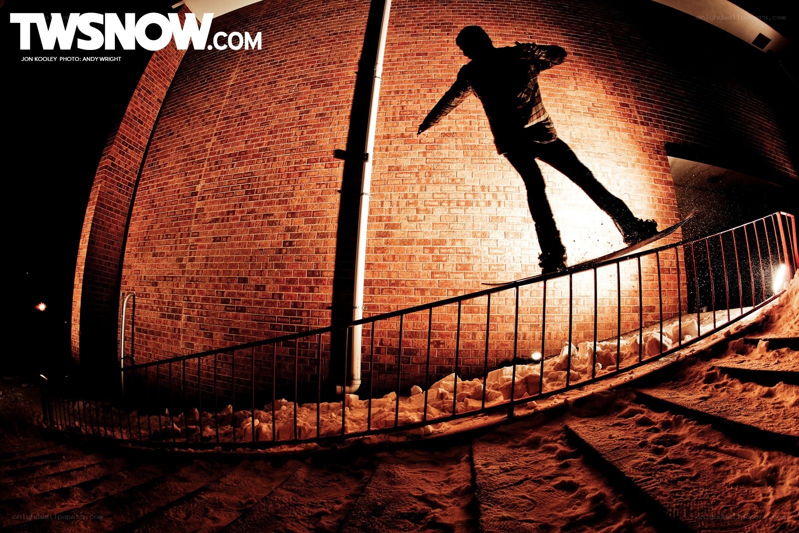 Snowboarder on rail at night