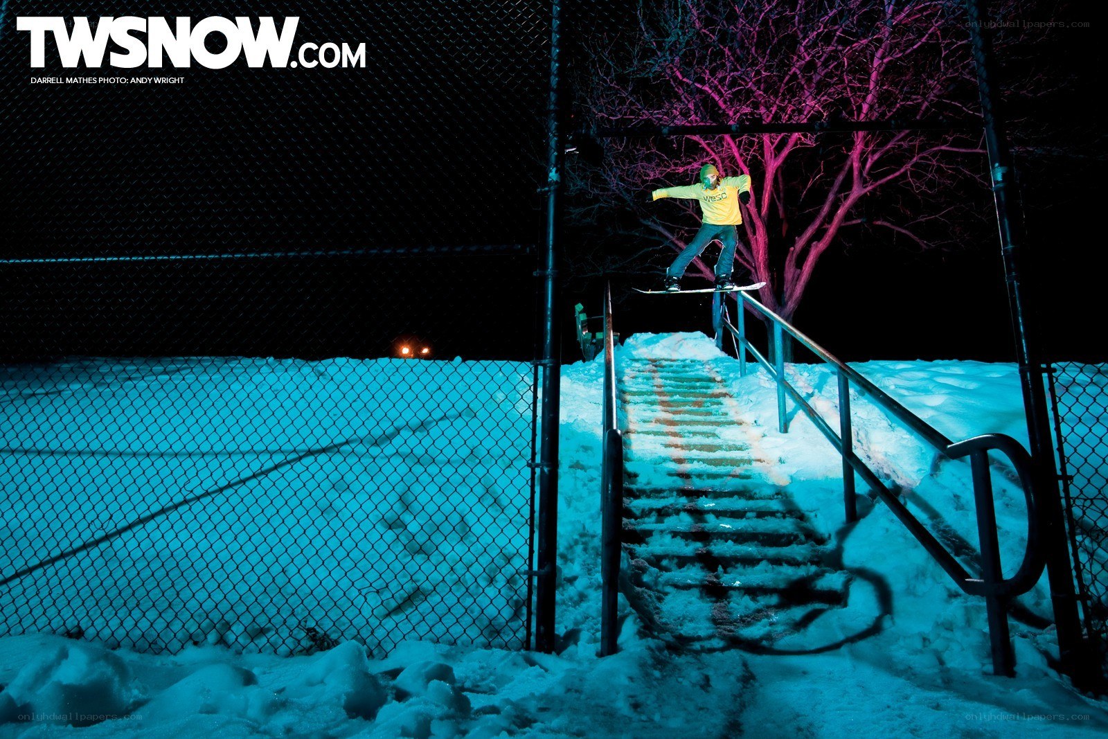 Snowboarder on rail at night