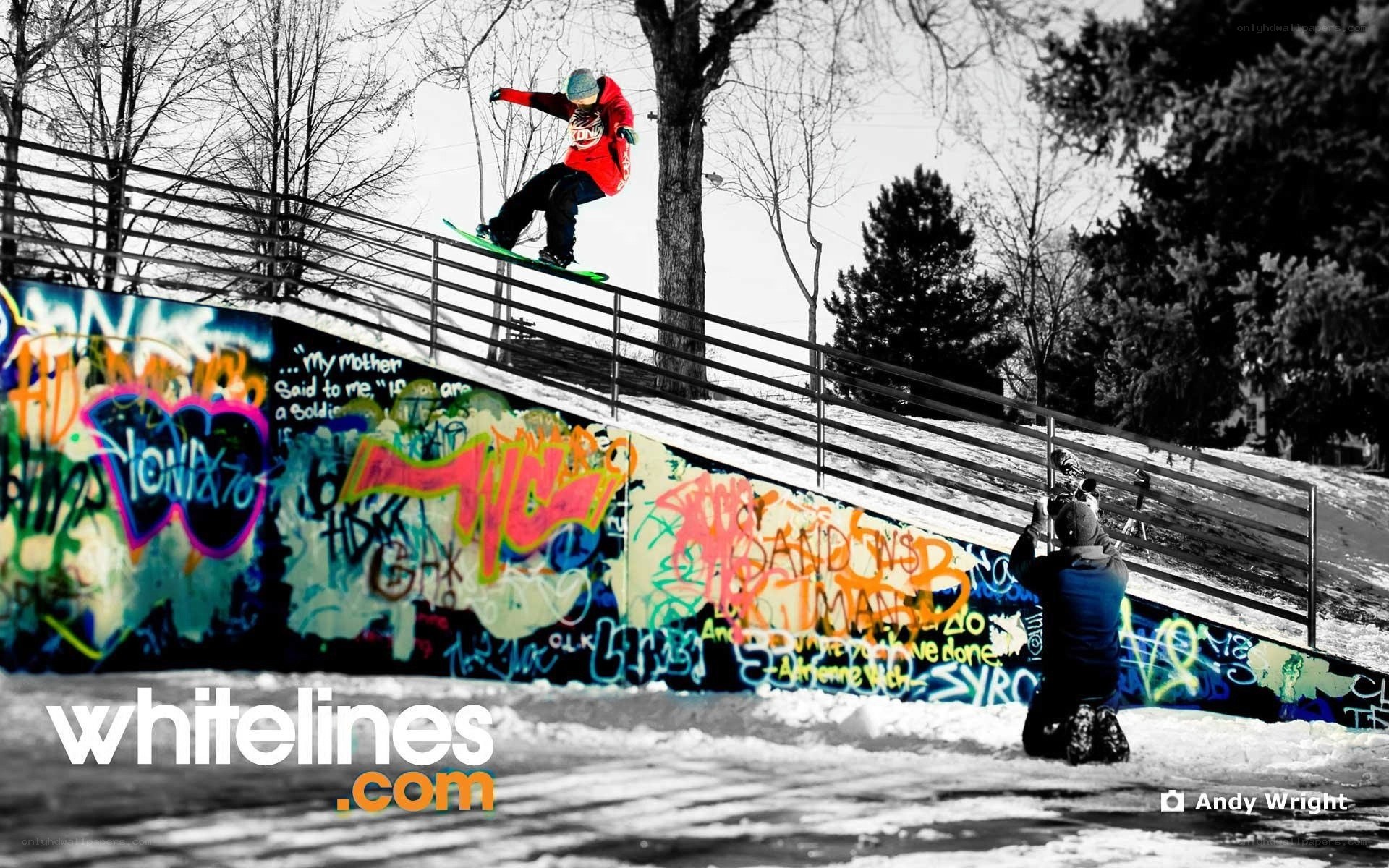 snowboarder on rail with graffiti