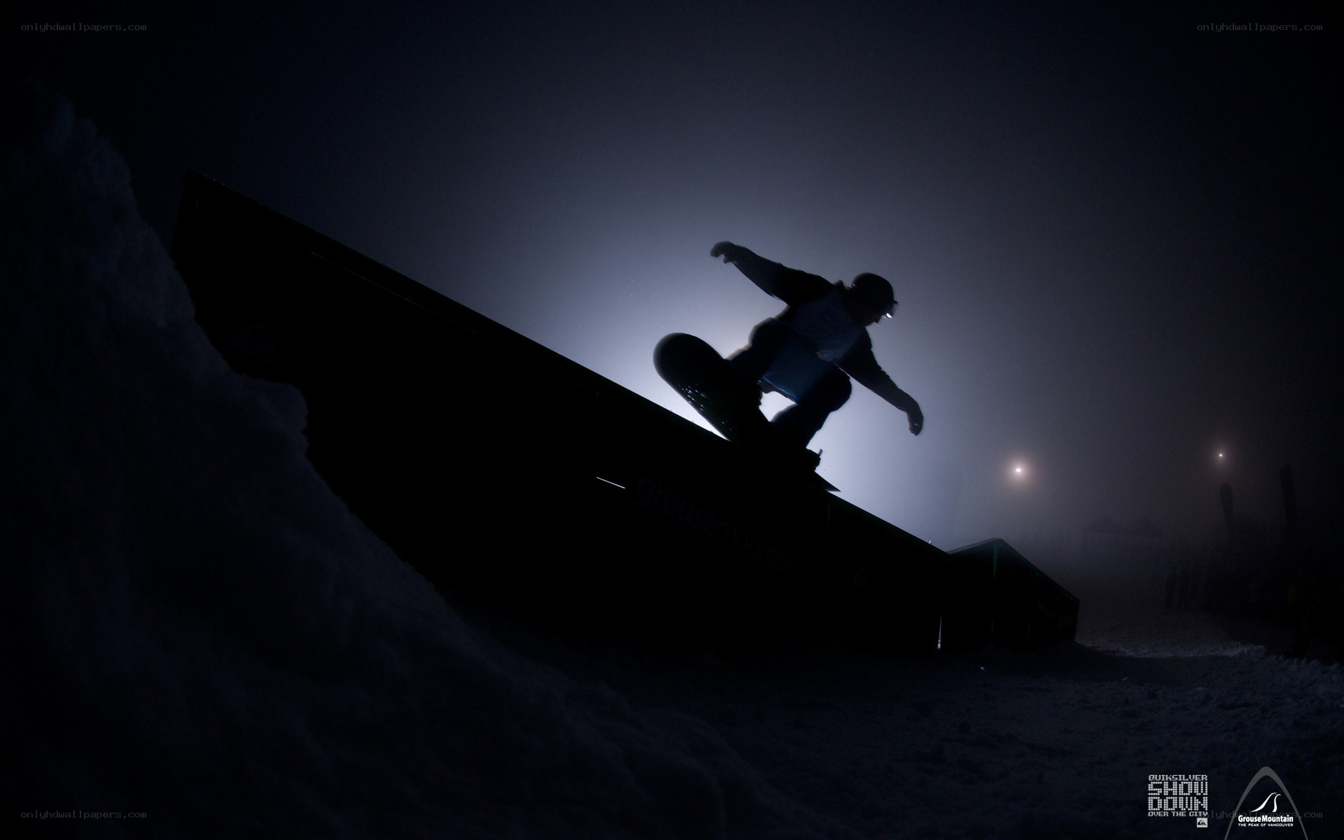 Snowboarder on ramp at night