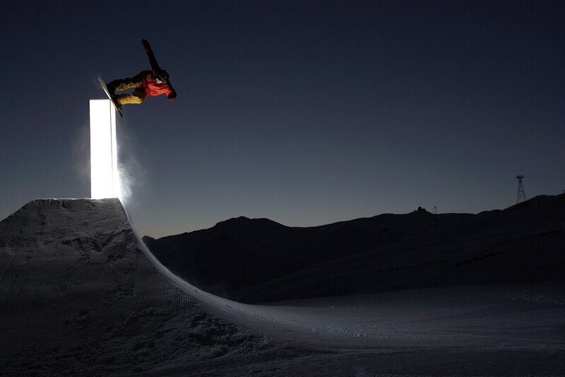 Snowboarder performing trick at night