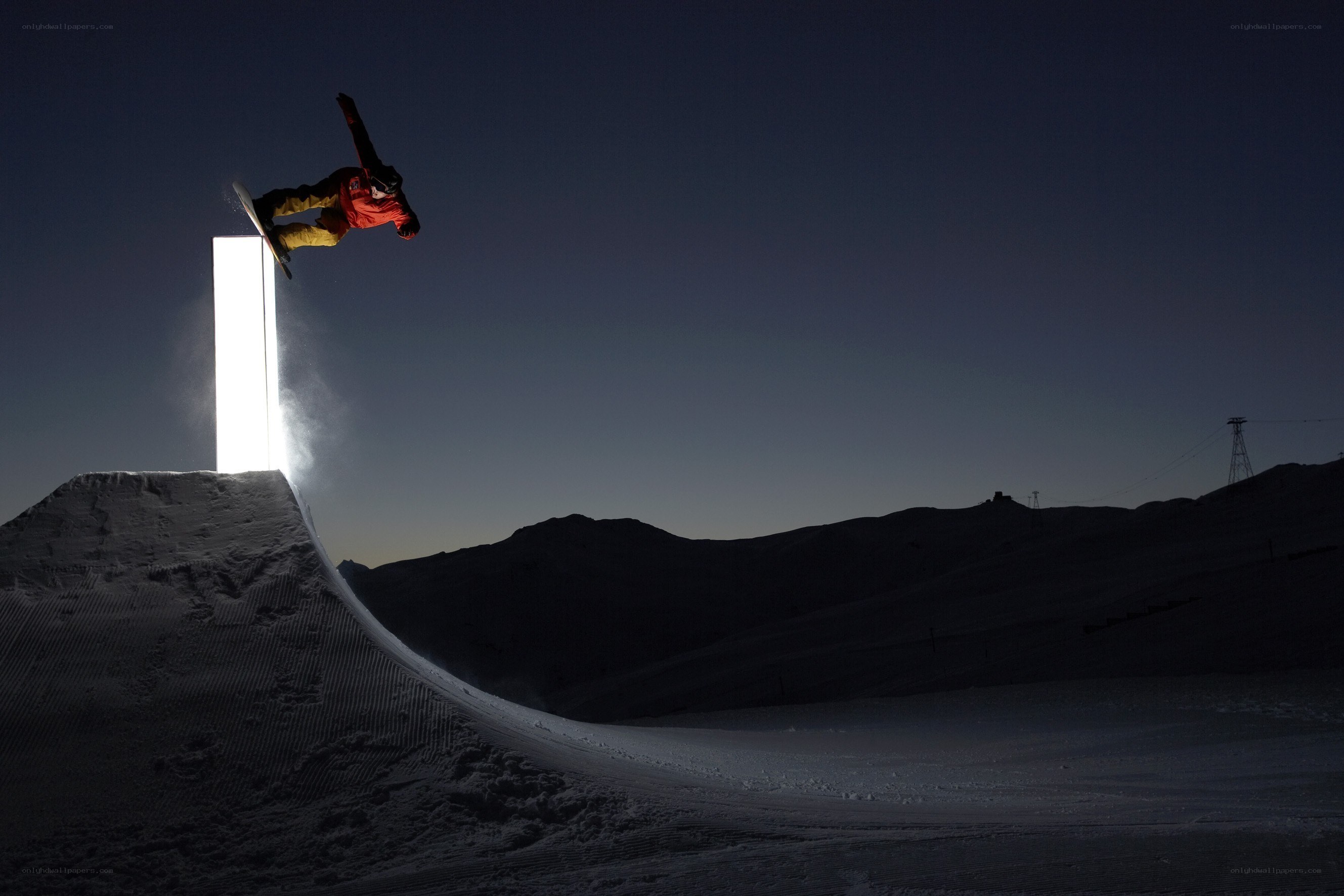 Snowboarder performing trick at night