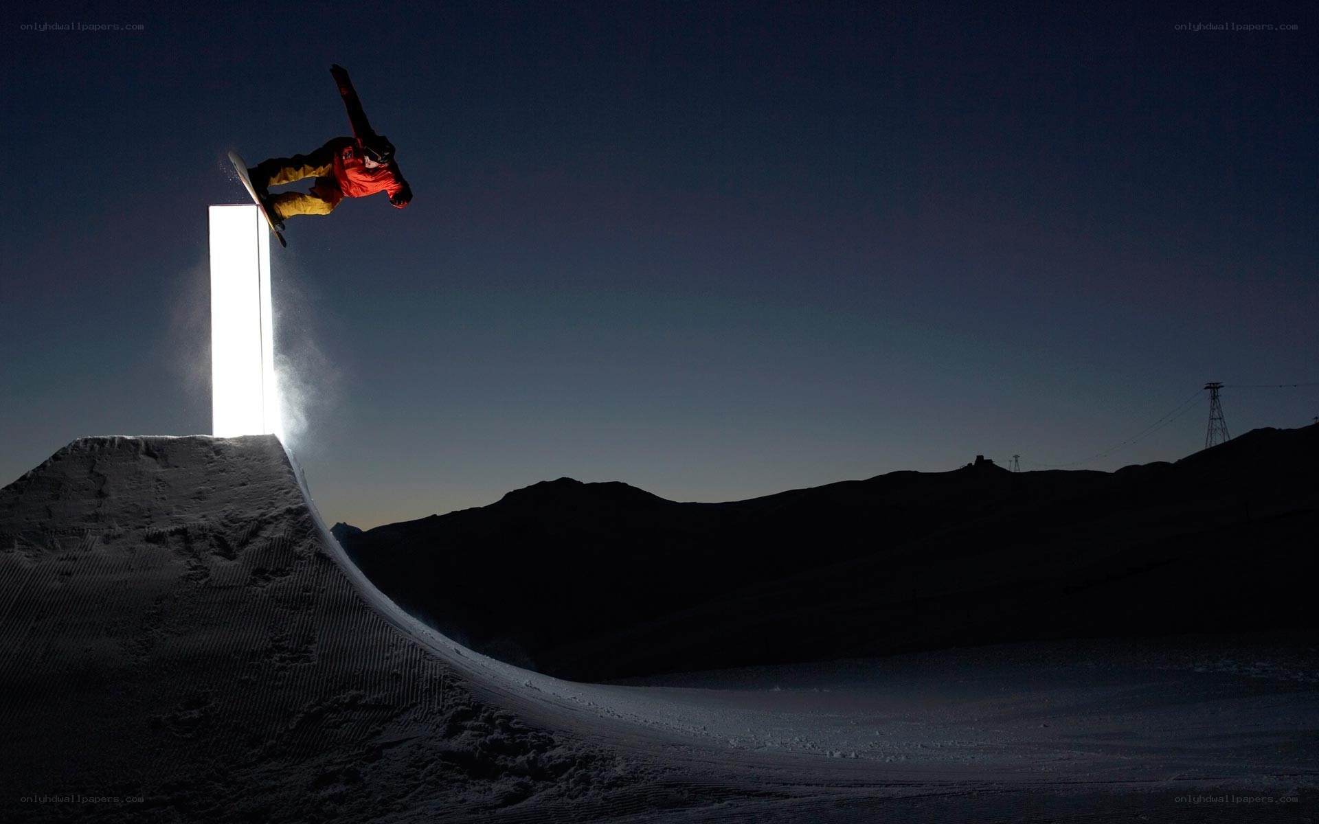 Snowboarder performing trick at night