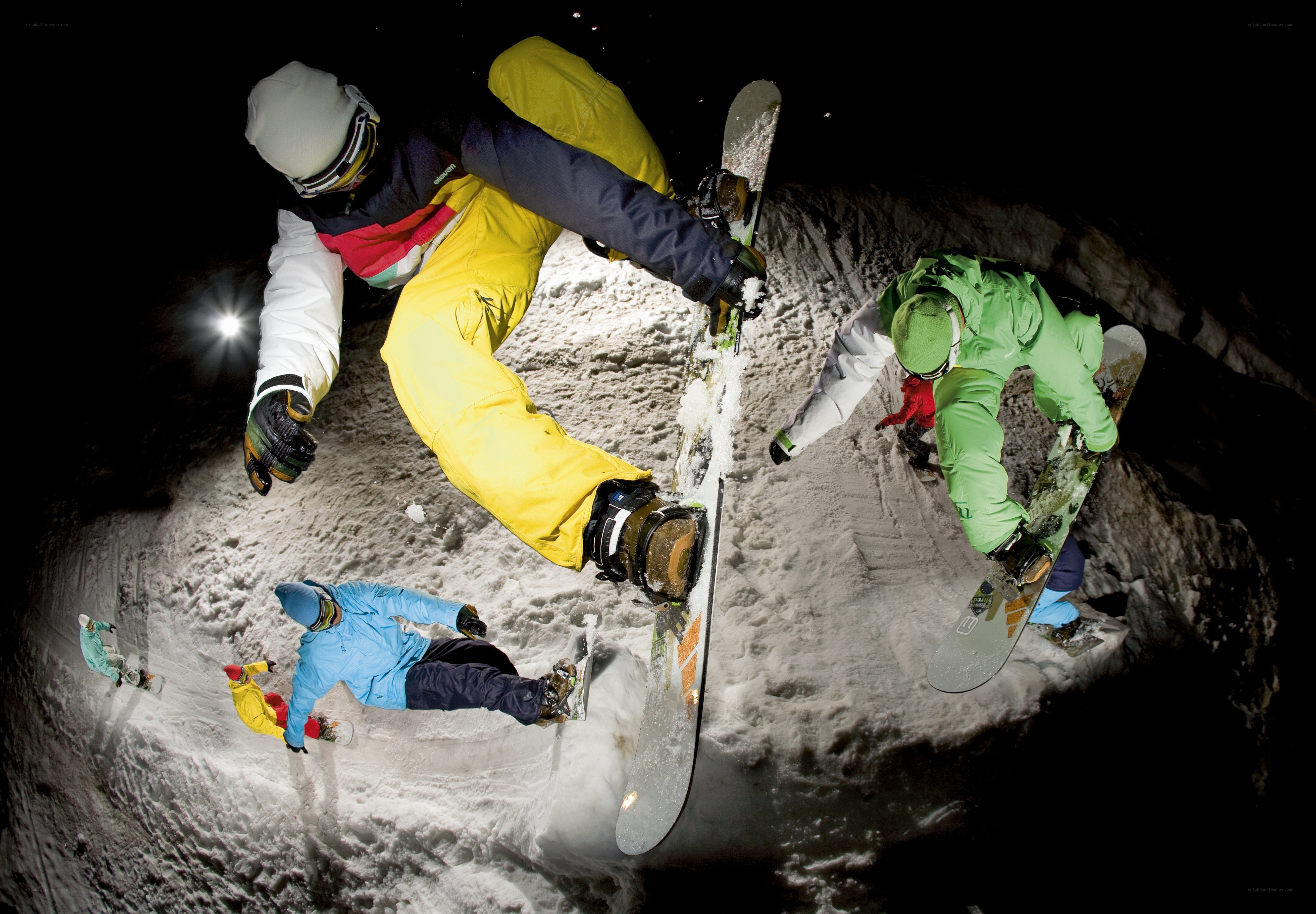 Snowboarders in action at night