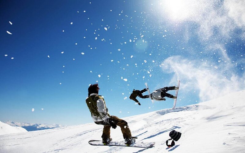 Snowboarders in action on a sunny day