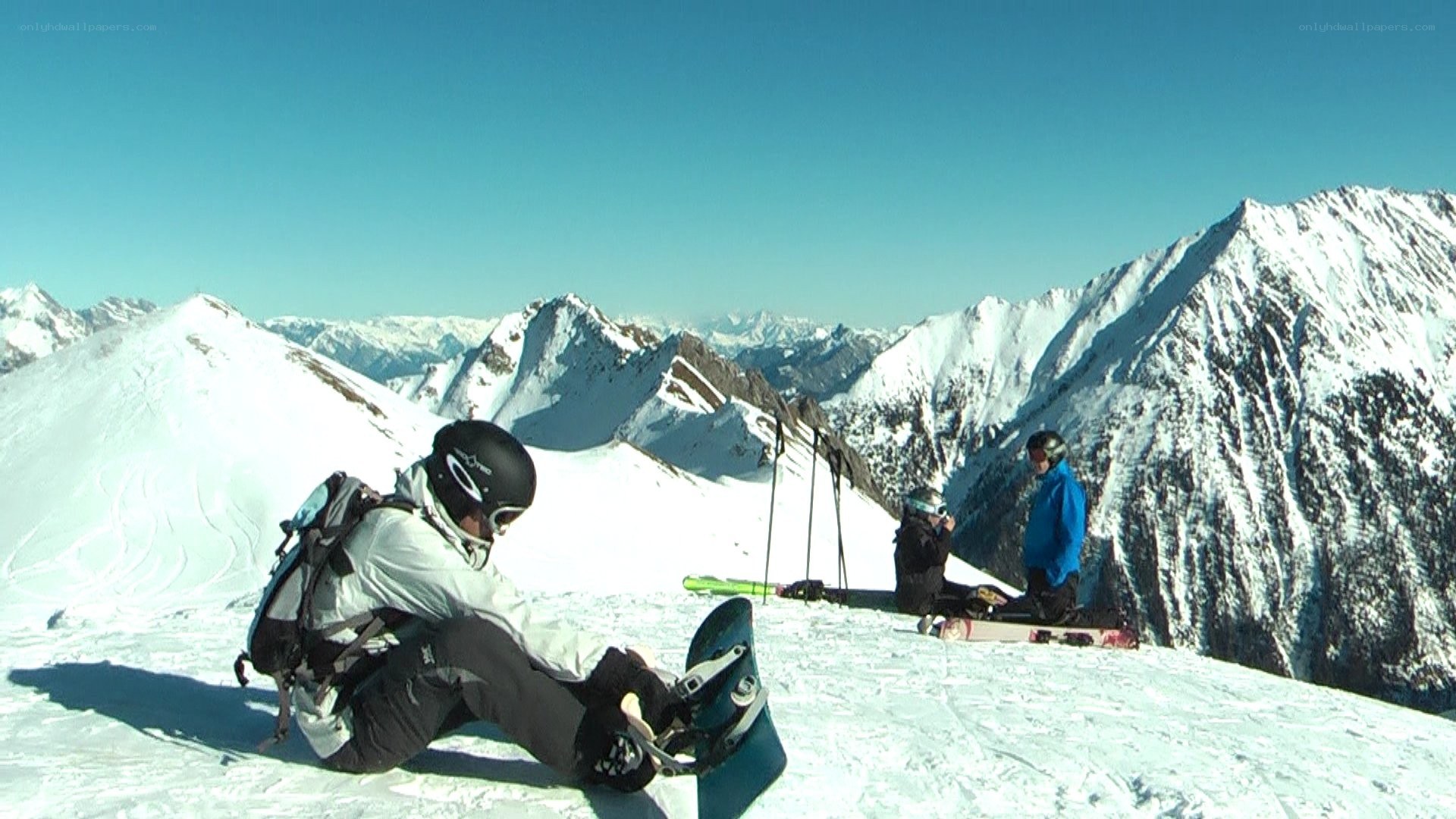 Snowboarders on a mountain peak