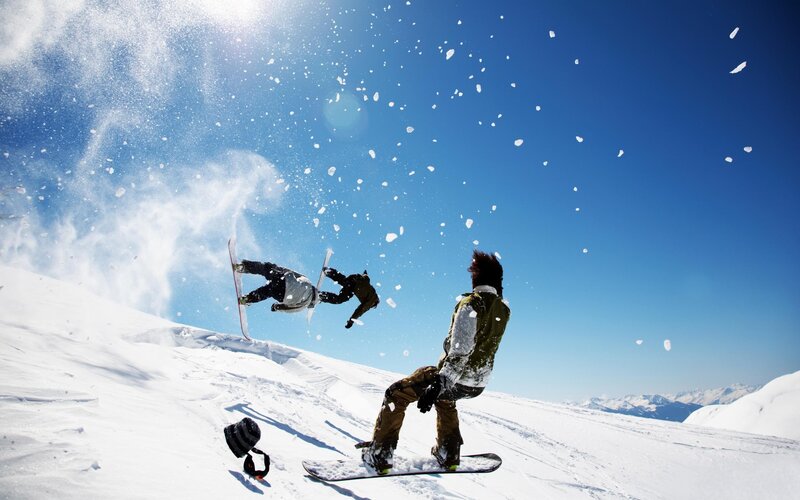 Snowboarders performing tricks