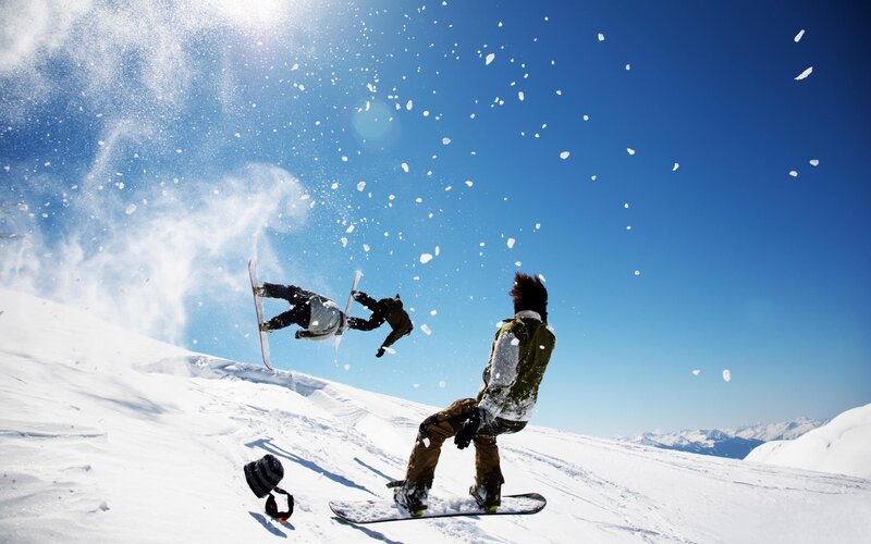 Snowboarders performing tricks