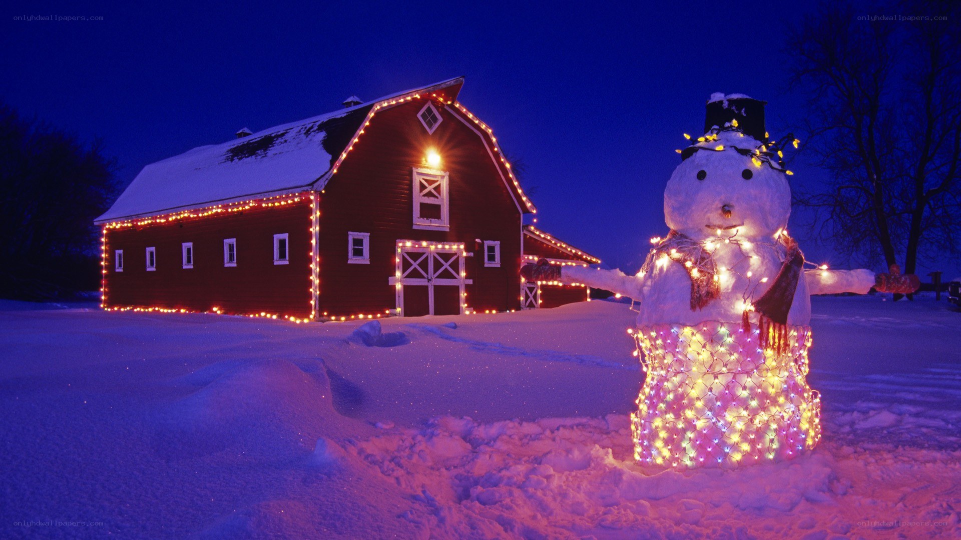 Snowman and barn at night
