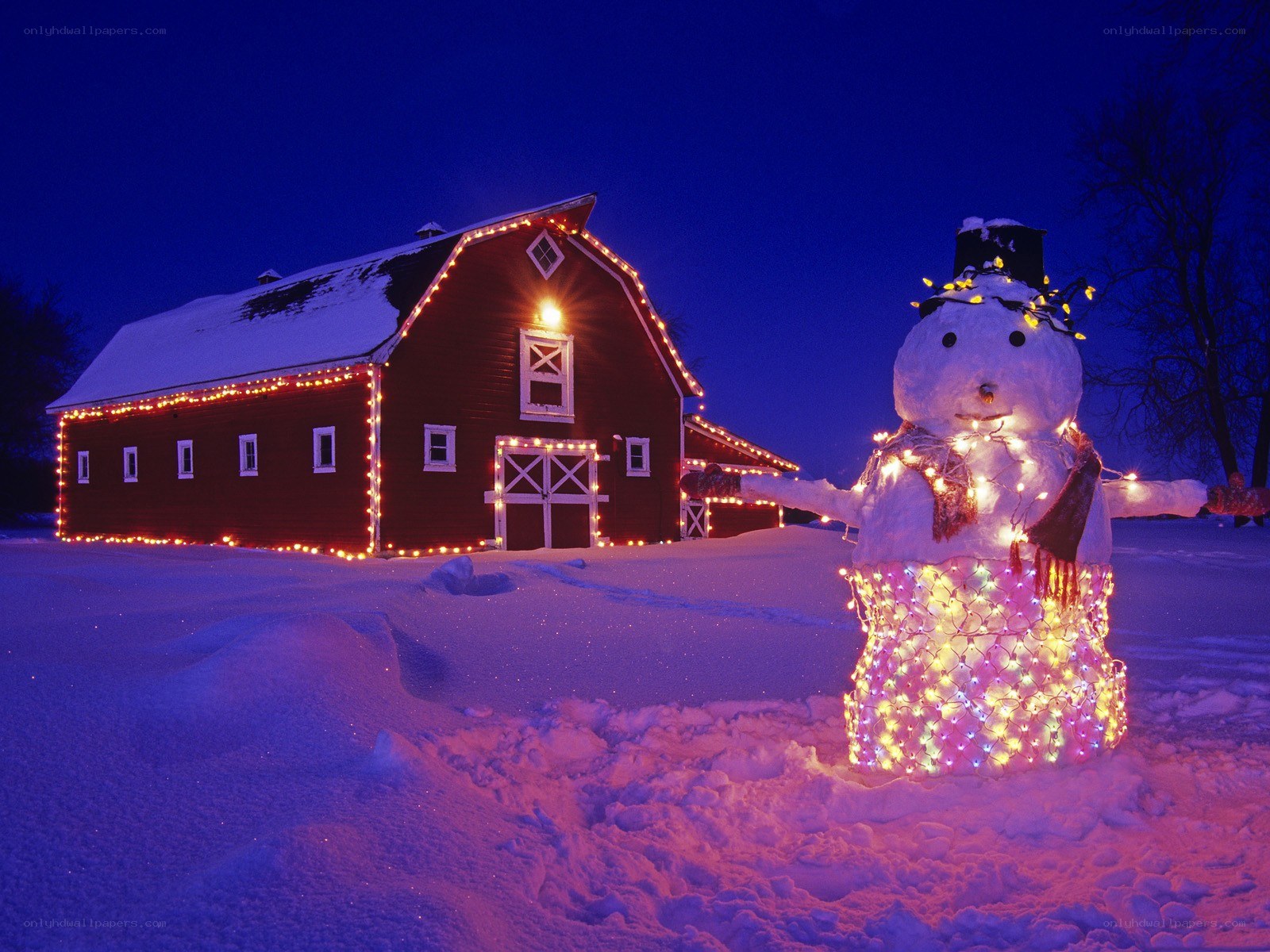 Snowman and barn at night