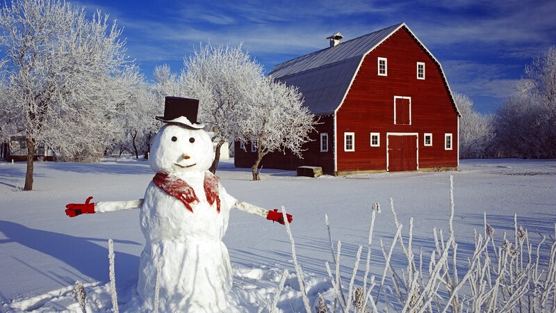 Snowman in front of red barn