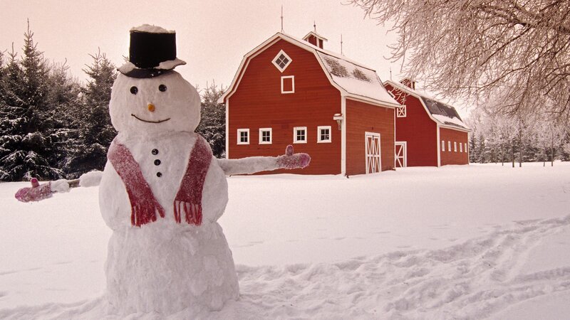 Snowman in front of red barn