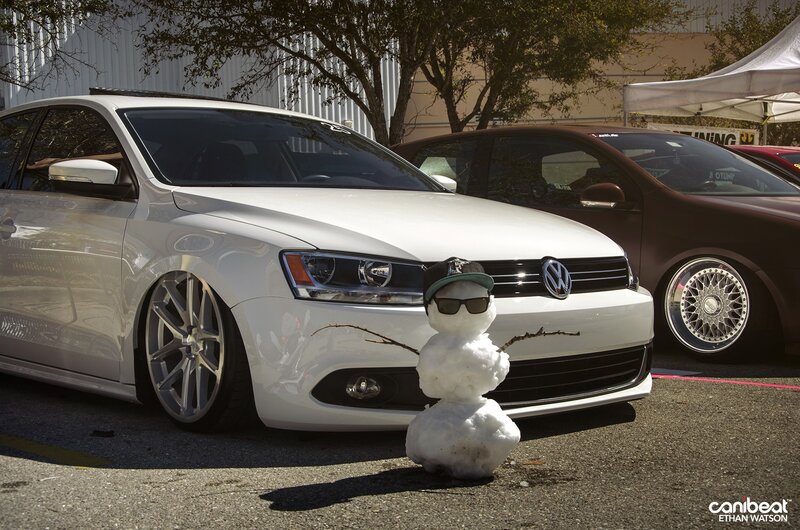 Snowman in front of white car