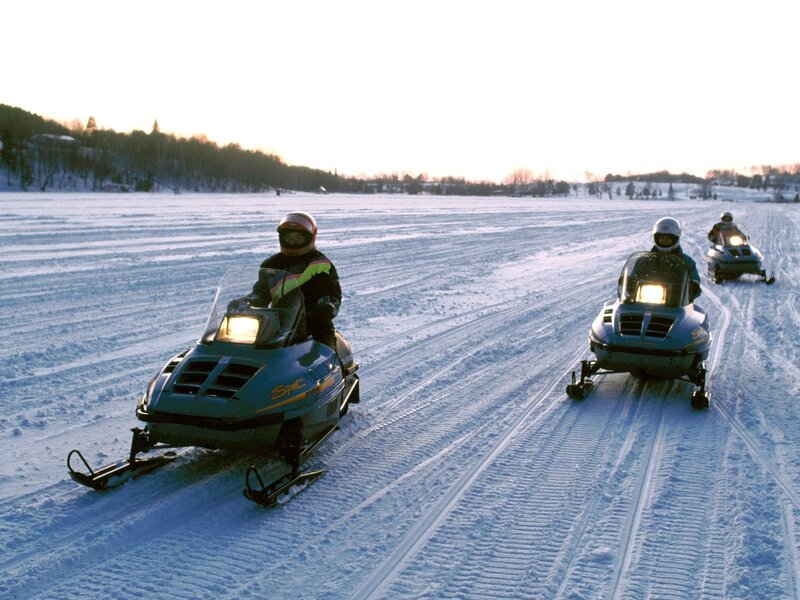 Snowmobilers on a frozen lake