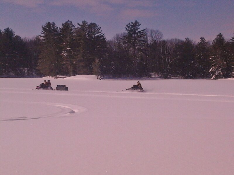 Snowmobilers on Frozen Lake