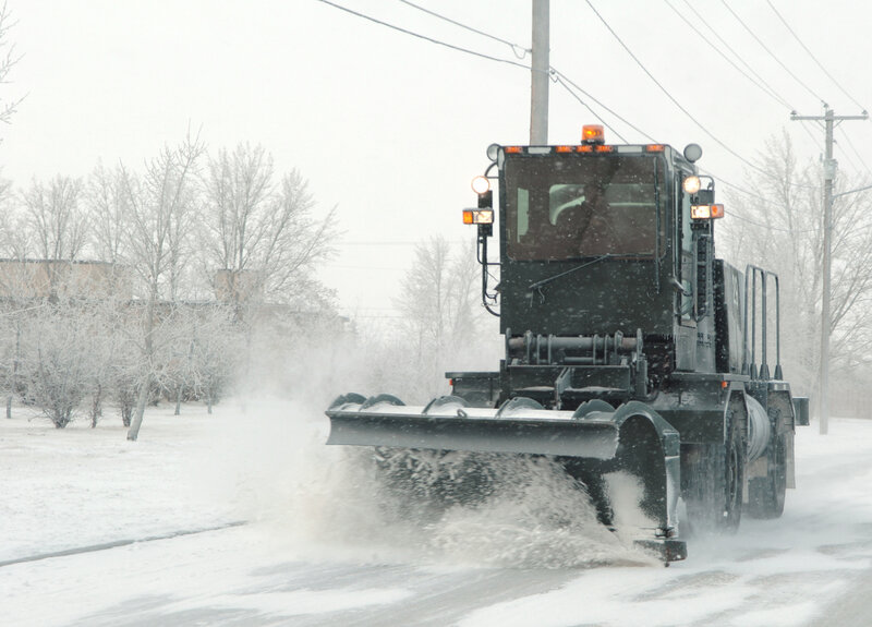 Snowplow clearing road in snowstorm