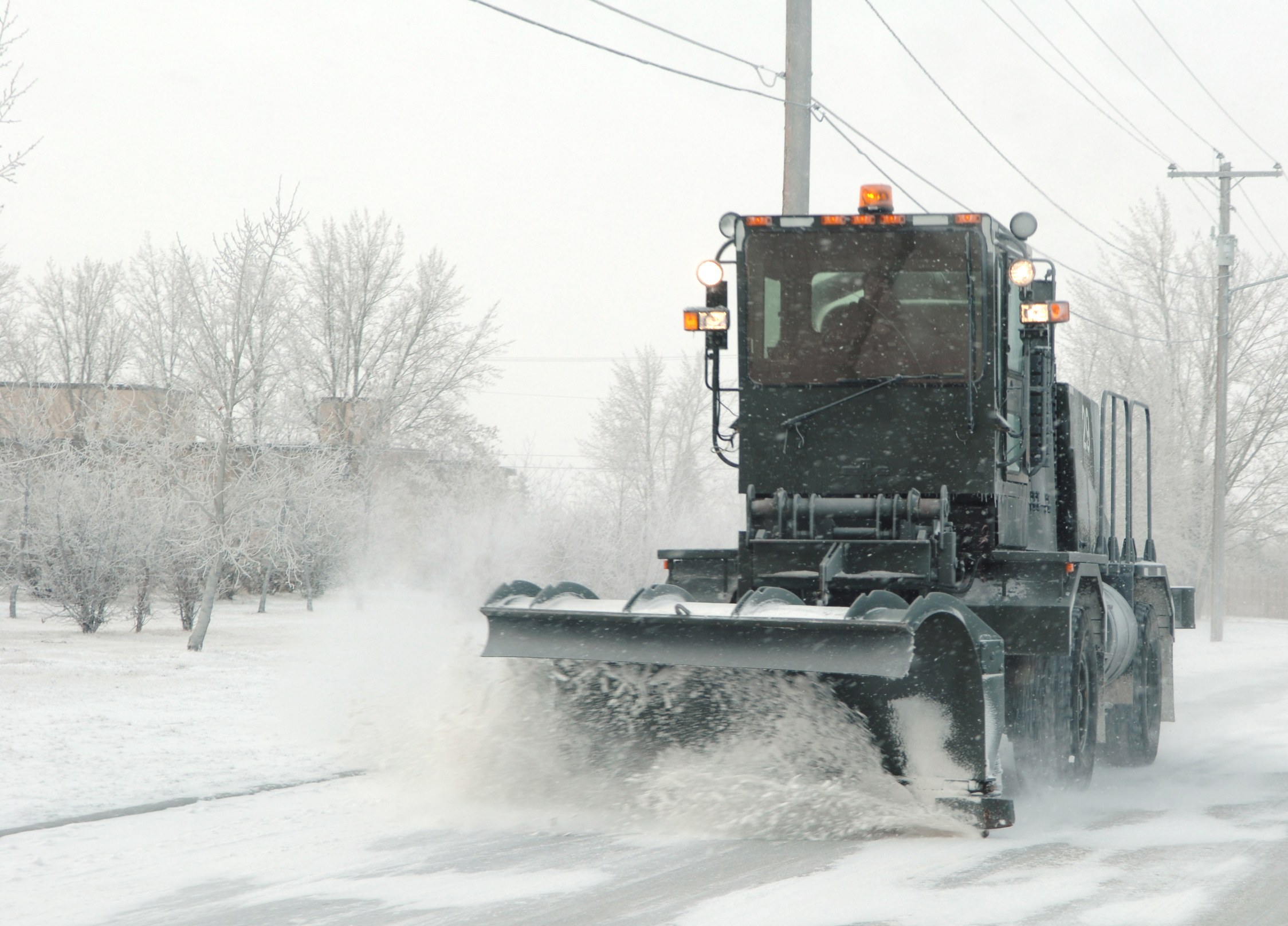 Snowplow clearing road in snowstorm