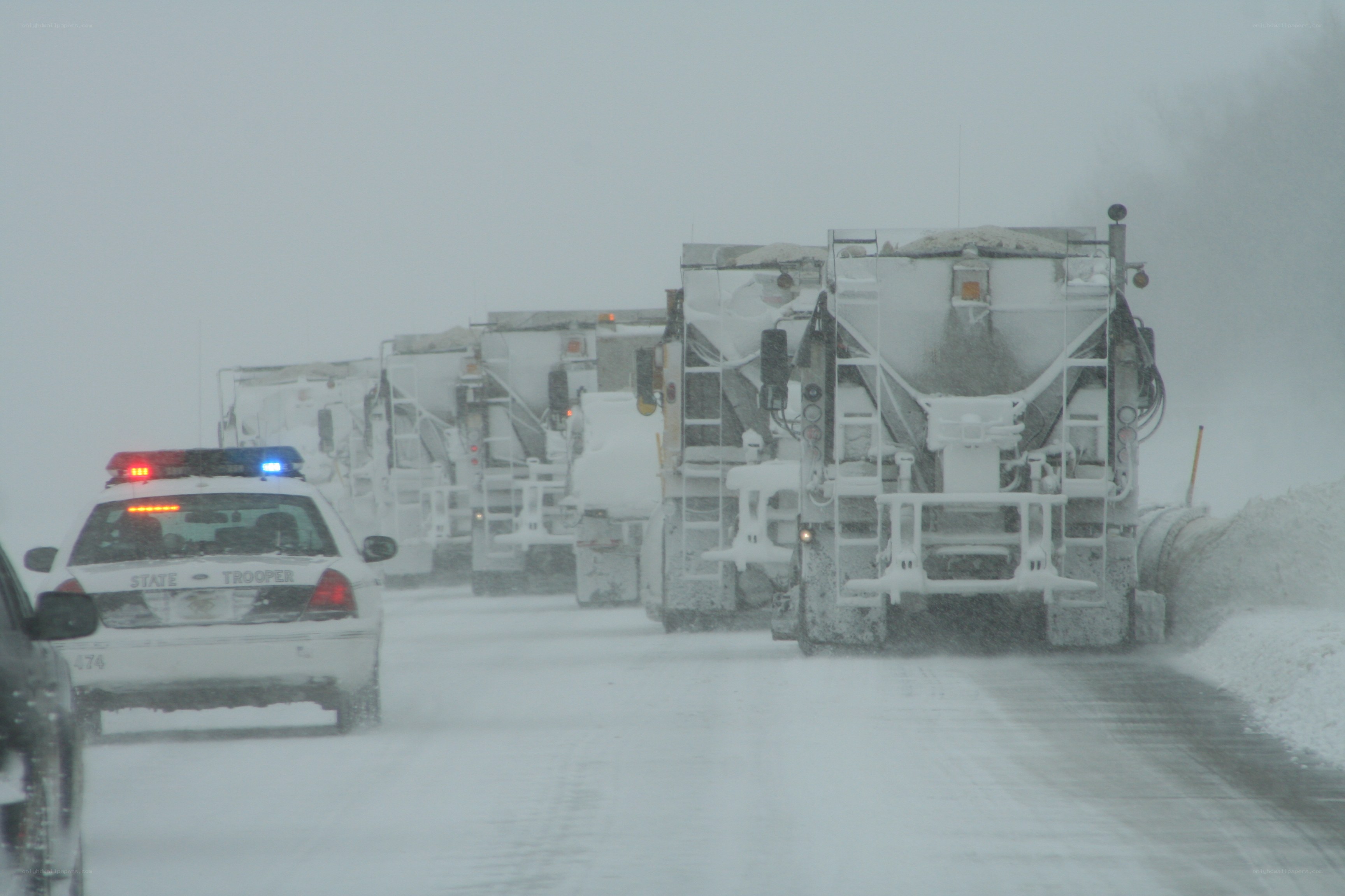 Snowplows clearing road in storm