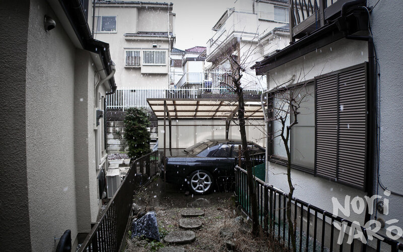 Snowy alley with parked car