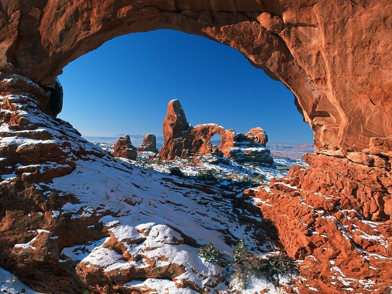 Snowy arch in red rock canyon
