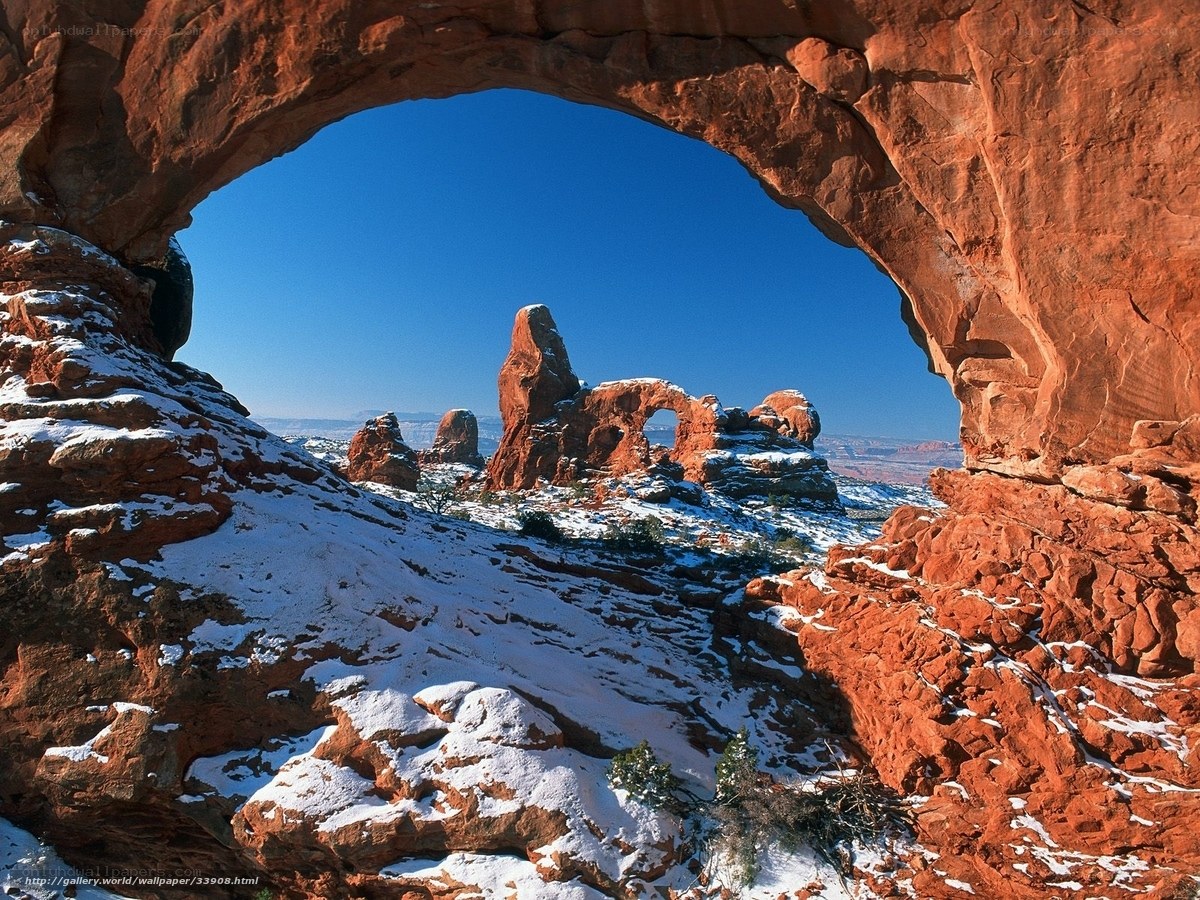 Snowy arch in red rock canyon