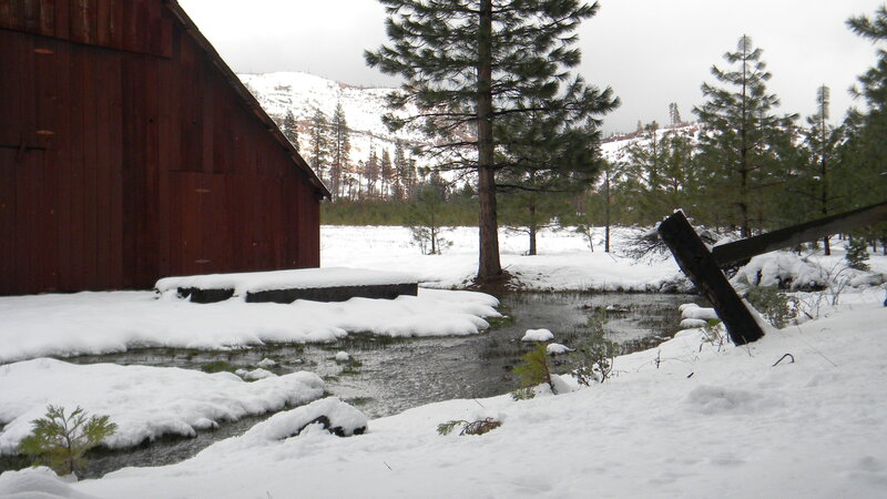 Snowy barn and stream