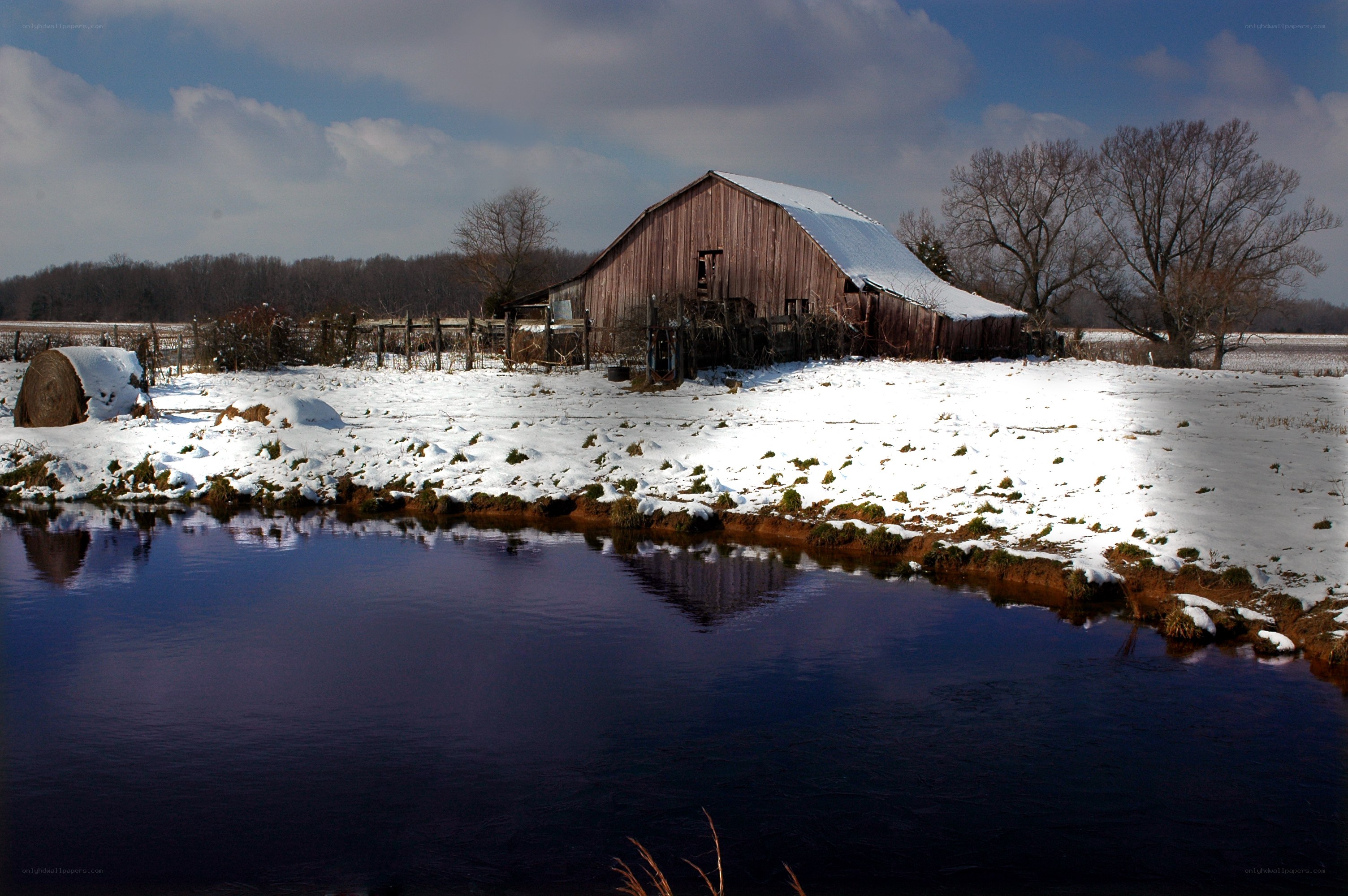 Snowy barn by a river