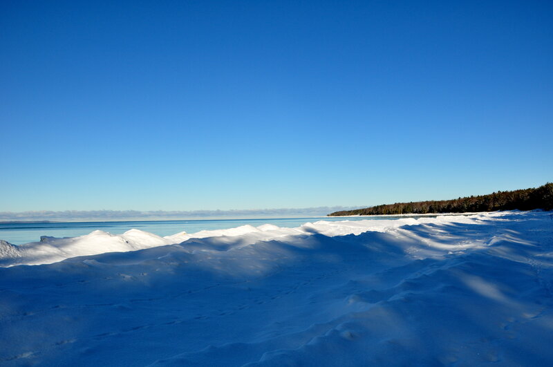 Snowy beach under clear blue sky