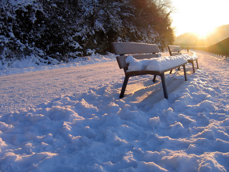 Snowy bench at sunset