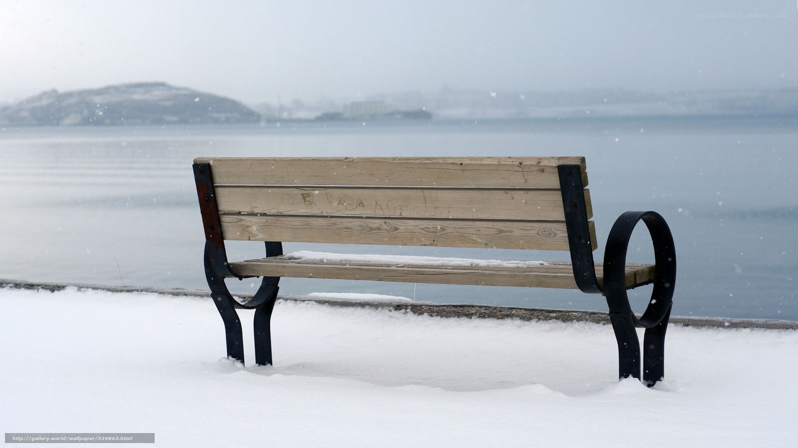 Snowy bench by the water