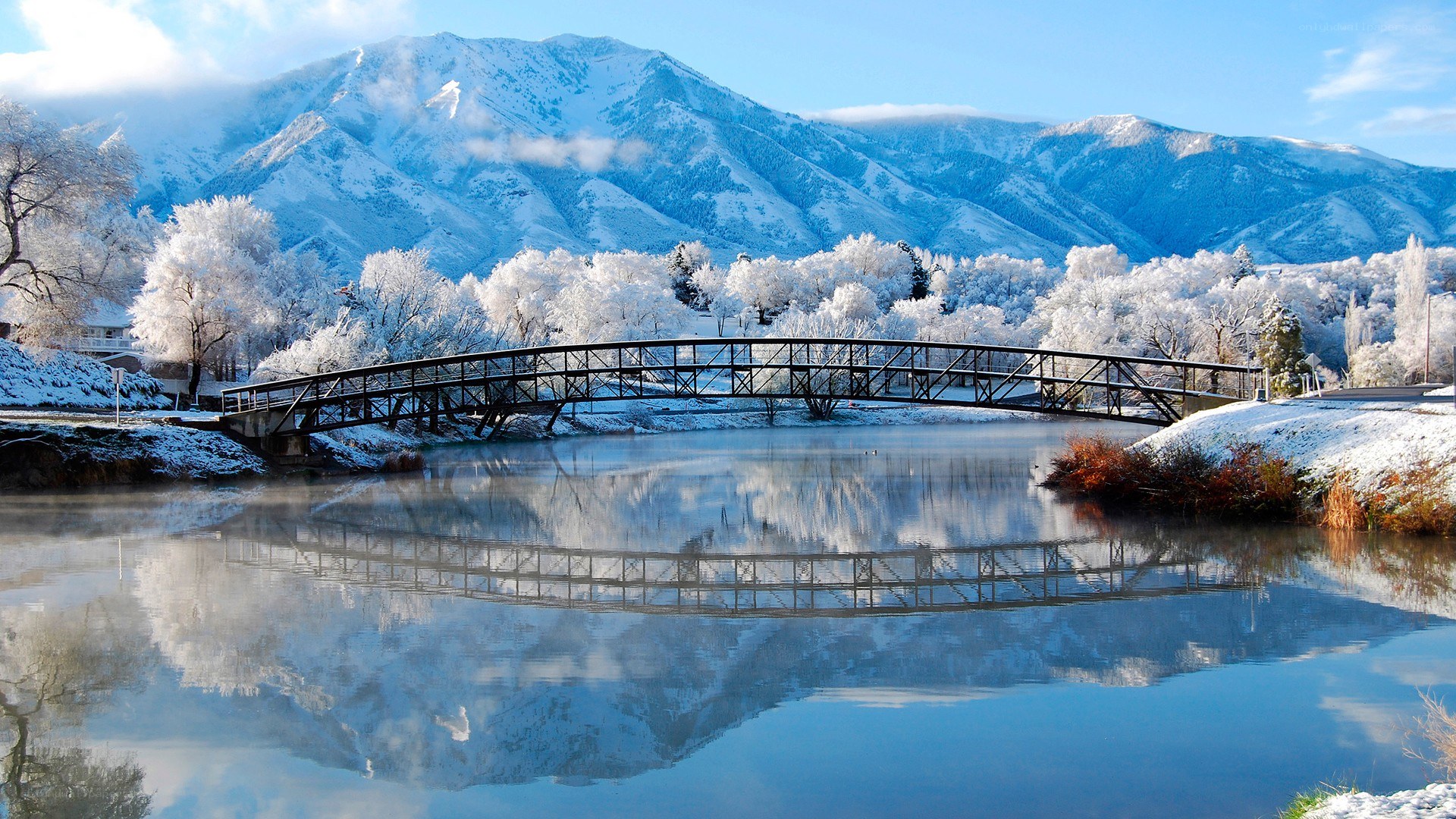 Snowy bridge over calm lake