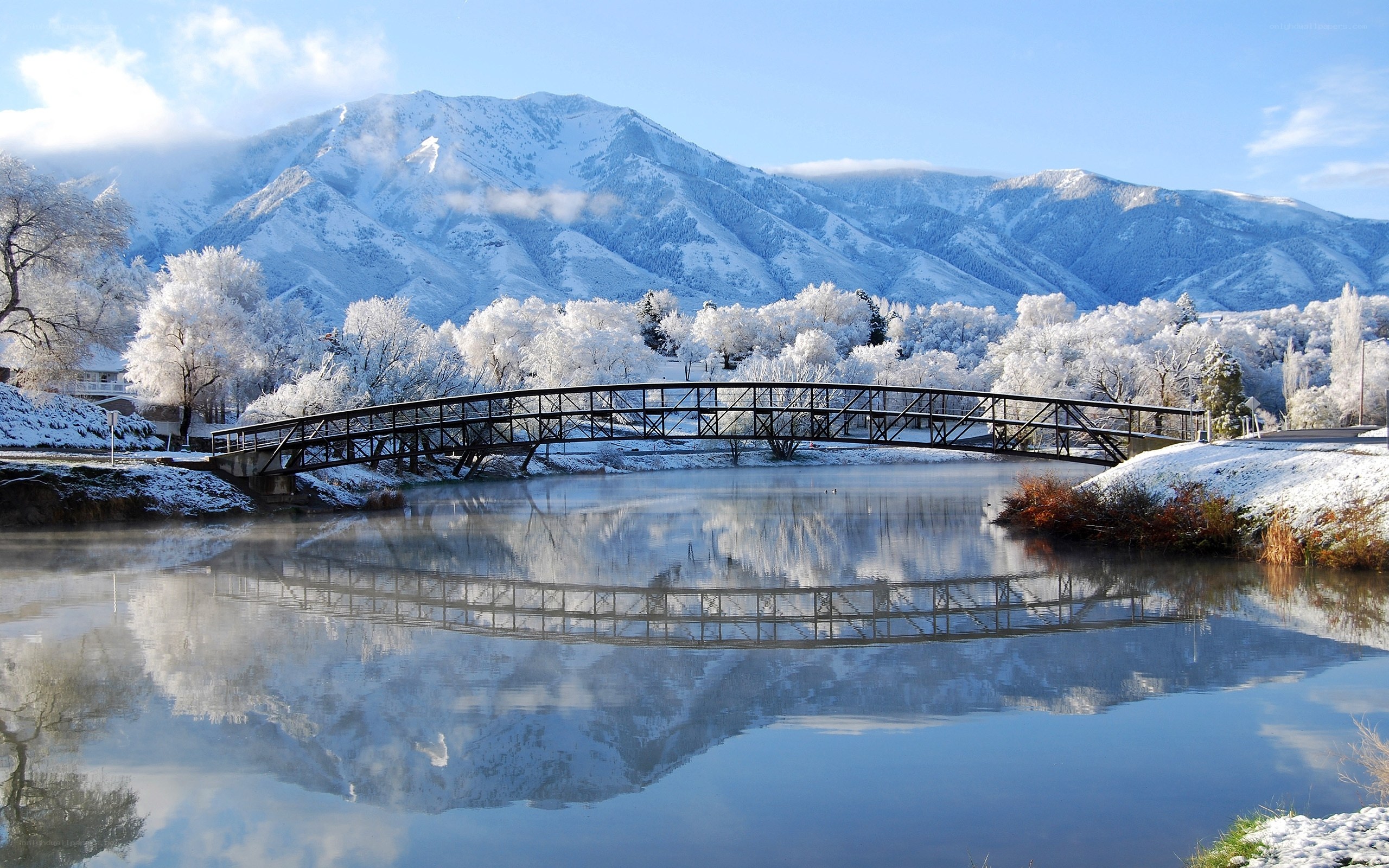 Snowy bridge over calm river