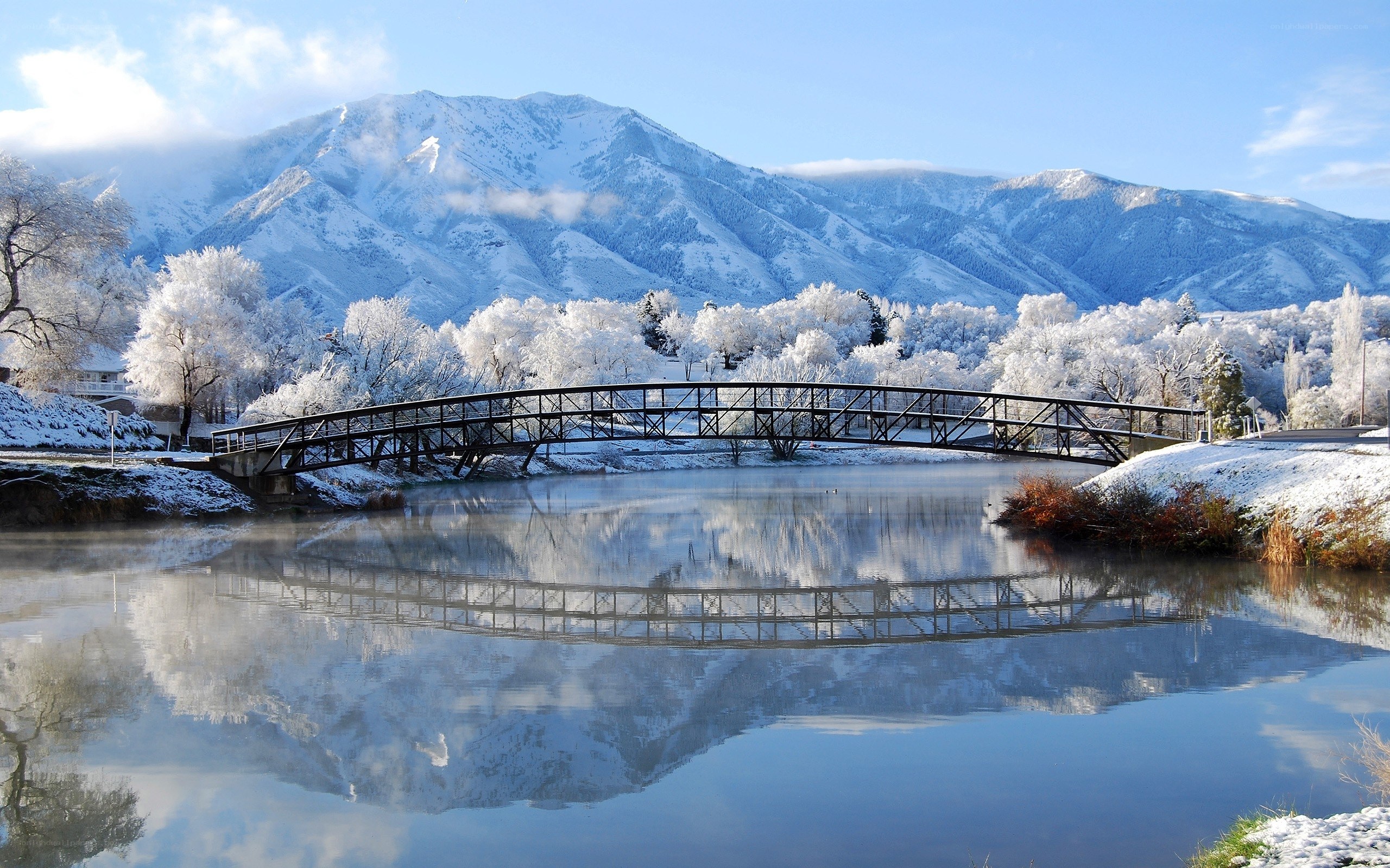 Snowy bridge over calm river