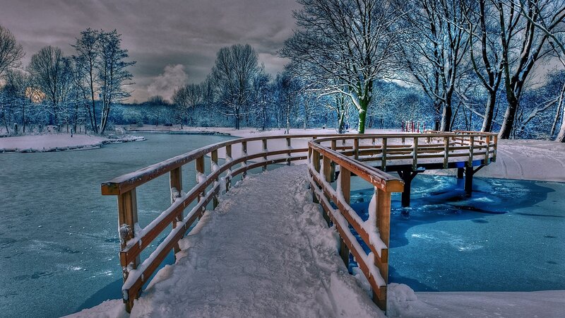 Snowy bridge over frozen lake